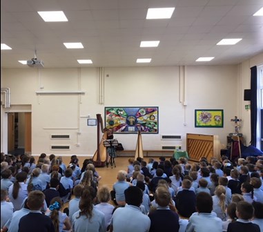 A photo of more pupils, facing away from the camera as they sit watching Natasha Gale perform